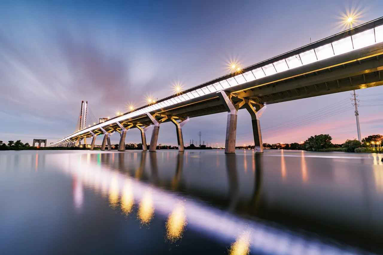 A long bridge stretching over calm water in the evening light.