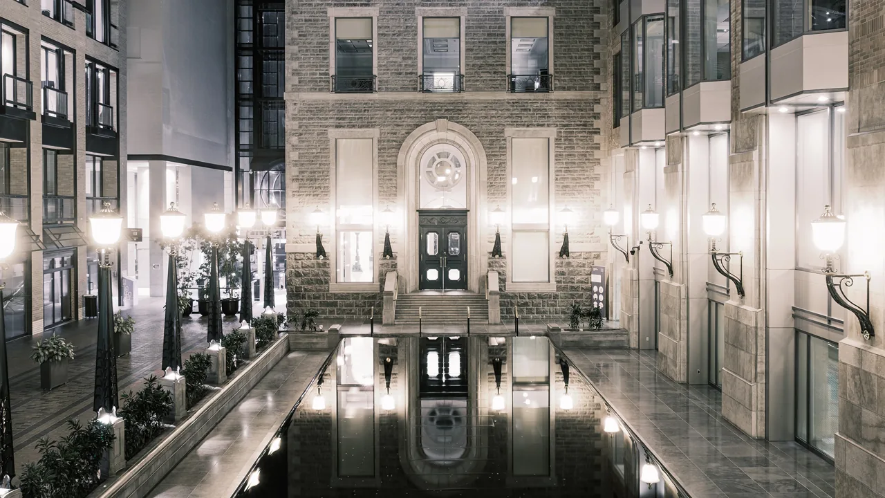 A symmetrical interior with glass, stone and illuminated architectural details.