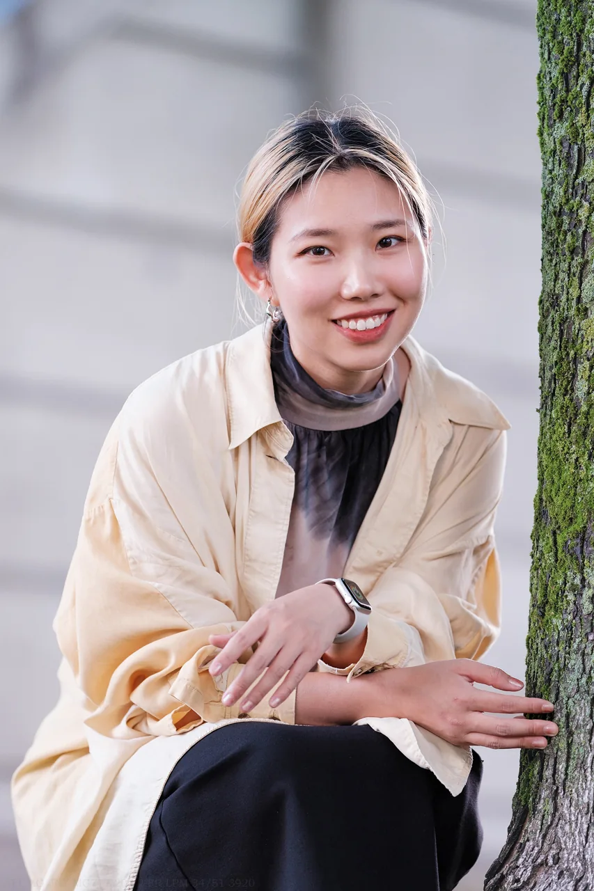 A relaxed outdoor portrait in a light jacket.